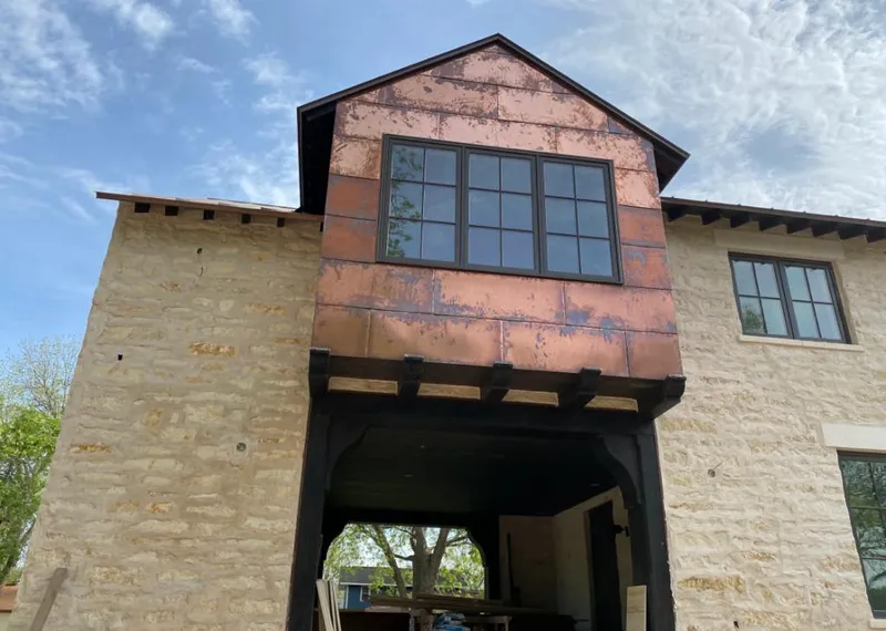 Copper metal panel facade on a stone building for Skylight Installation in Nuevo